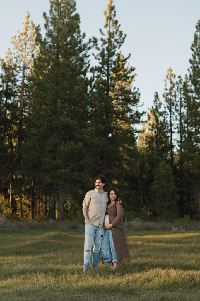 Maternity Photos in Lake Tahoe, couple standing in a meadow with trees
